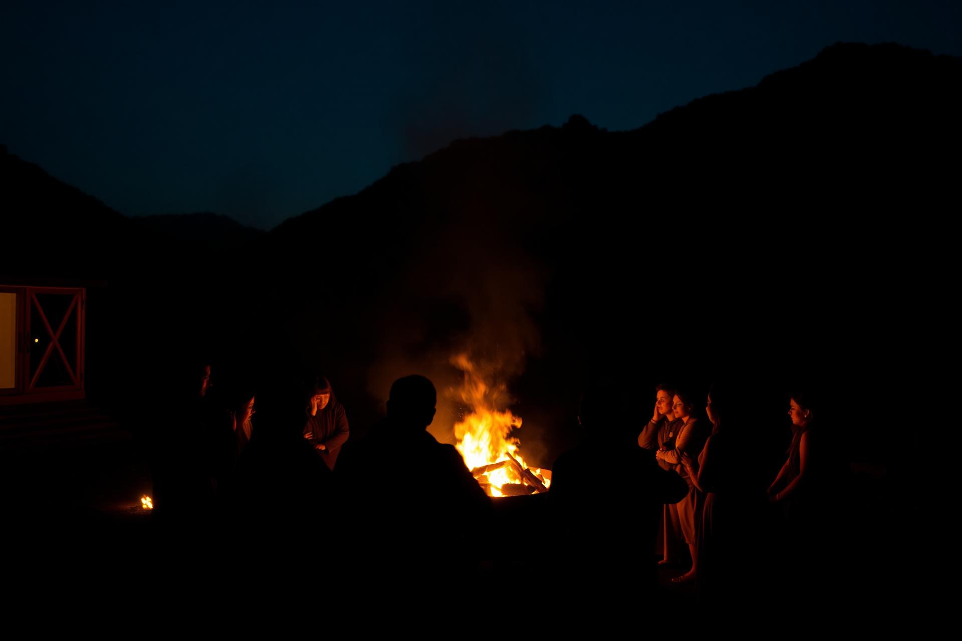 Group gathered around a bonfire at a retreat